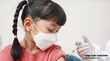 A girl wearing a facemask gets vaccinated