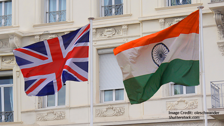 Picture of a British and an Indian flag on flagpoles next to each other.